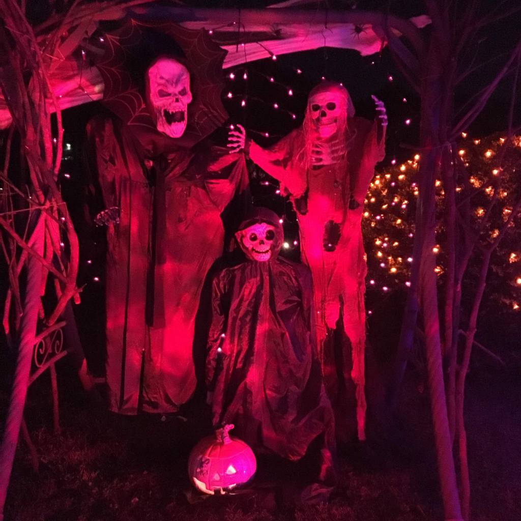 Skeleton family photo booth lit up by rotating orange lights.