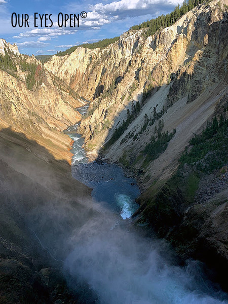 Mist forms as the water drops from the fall line at the Lower Falls in Yellowstone National Park in the Grand Canyon.