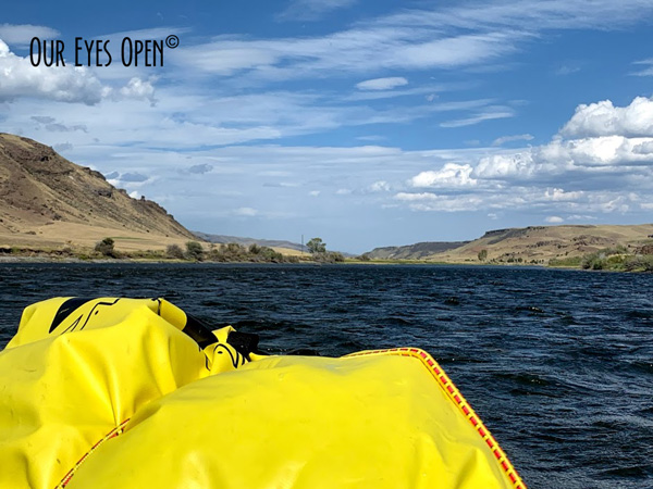 With the dry bag in the foreground and the mountains on either side of us paddling the Yellowstone River.