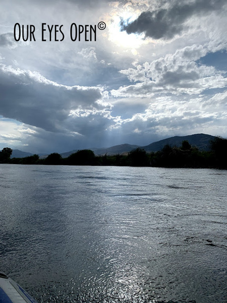 Sun rays provide a moonlight reflection on the Yellowstone River as a storm approaches.