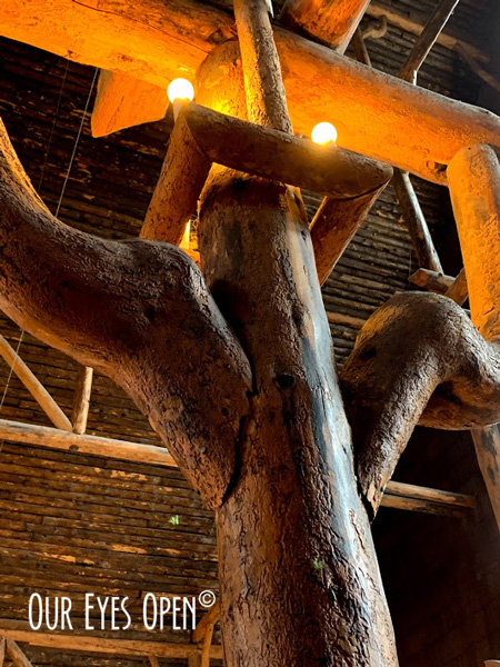 The log pillars with ambient lighting inside the historic Old Faithful Inn.