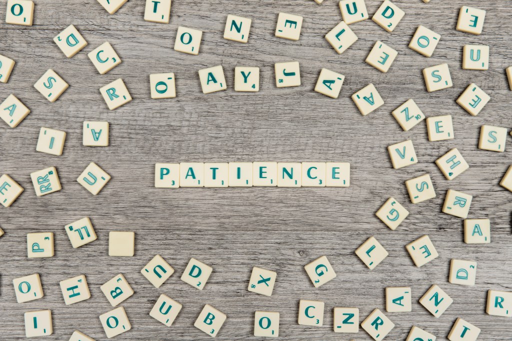 Practice patience scrabble tiles spelling out PATIENCE.