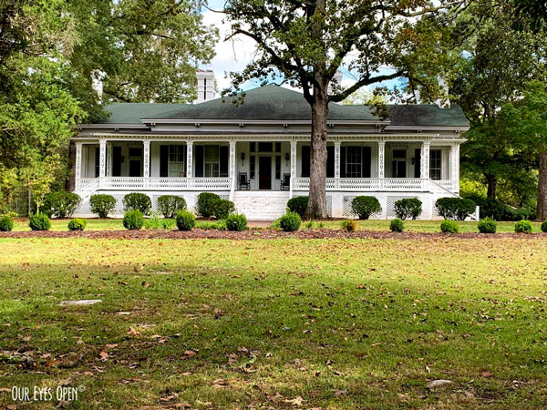 Large white house with a beautiful front porch on a large plot of land in Georgia.