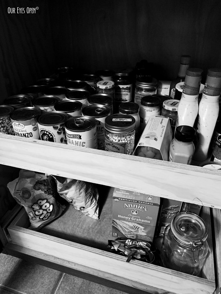 Pantry filled with canned goods, graham crackers, condiments and Blow Pops.