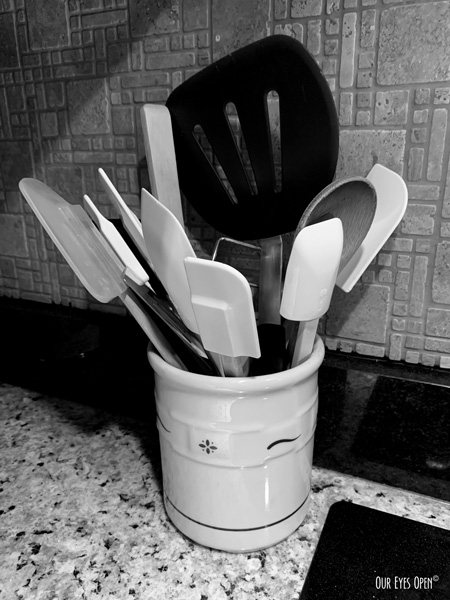 Utensils, mostly spatulas in a crock on the counter.