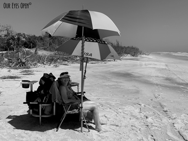 Me sitting on the beach at Little Talbot Island State Park under two umbrellas.