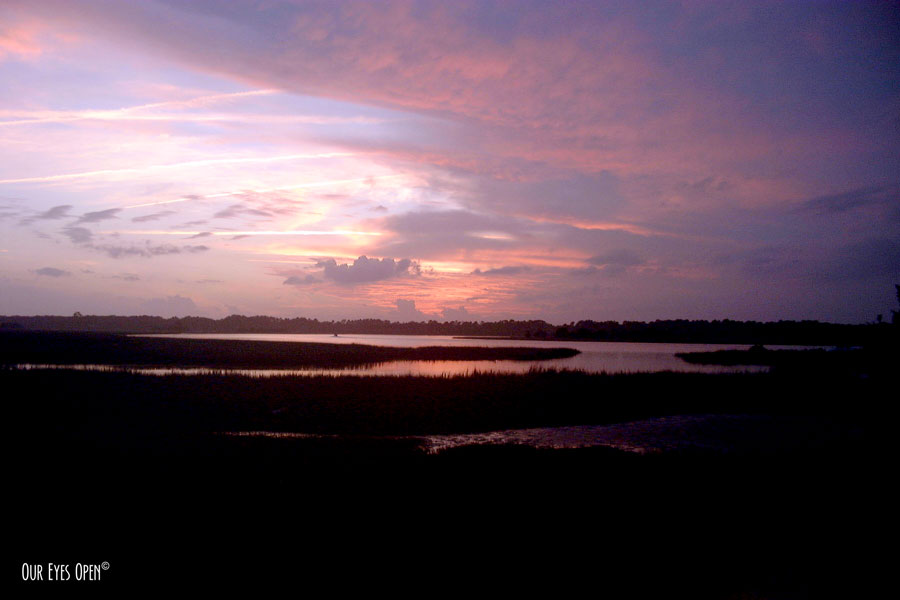 A sun moving towards the horizon at sunset overlooking the salt marsh in Jacksonville, Florida.